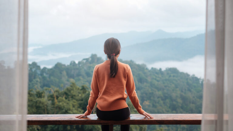 Woman sitting and overlooking mountains to celebrate lent