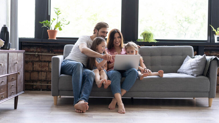 Family looking at a laptop marking their family calendar with spring activities